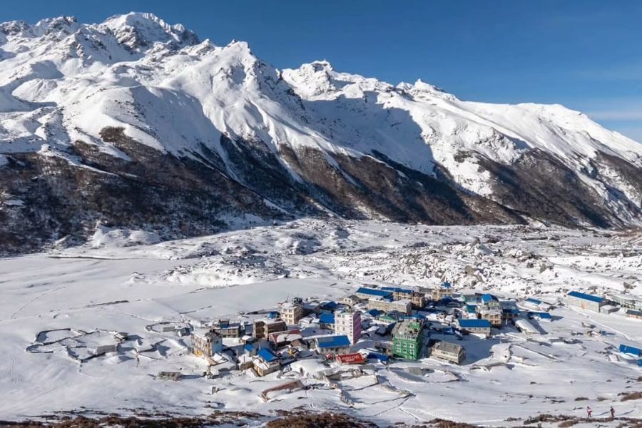 Aerial view of snow-covered village in Langtang Valley surrounded by Himalayan peaks